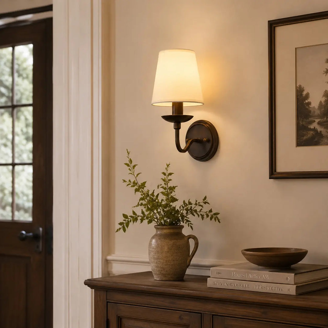 Antique bronze wall sconce above an entryway console