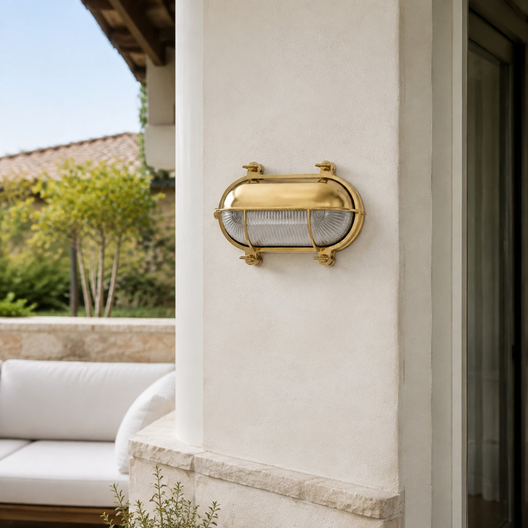 Aplique de pared Ivoran Bulkhead - Luz industrial vintage de vidrio con jaula de latón para exteriores y baño