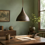 Load image into Gallery viewer, Aged brass pendant light over a dining table with soft daylight