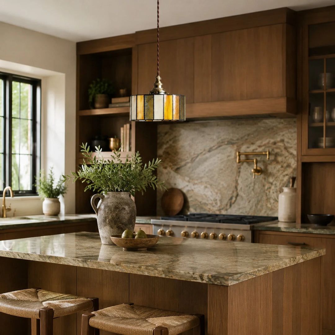 Brass glass pendant light over a marble kitchen island