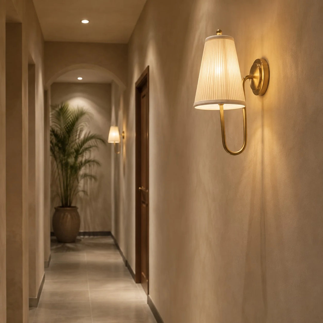 Brass fabric wall sconce lighting a hallway wall