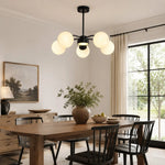 Load image into Gallery viewer, Black five-light chandelier above a dining table