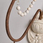 Load image into Gallery viewer, Close view of the curved iron arm and draped wood beads