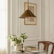 Brown leather pendant lamp above a vintage dining table