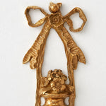 Bild in Gallery-Viewer laden, Close view of the ornate brass bow and floral wall plate