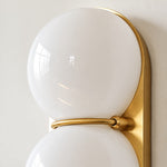 Charger l'image dans la visionneuse de galerie, Close view of two white glass globes on a brass backplate