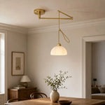 Load image into Gallery viewer, Gold pendant in a warm dining room