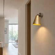 Brass cone wall lamp installed in a hallway