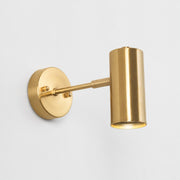 Brushed brass cylinder wall sconce on a white background