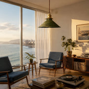 Distressed green pendant lamp installed in a warm living room by large windows