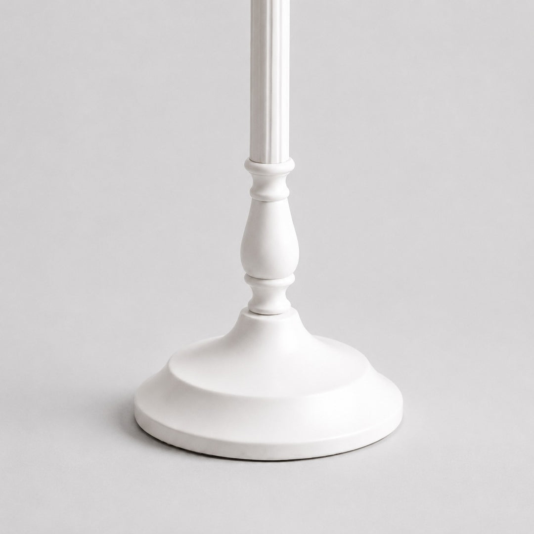 Close-up of sculpted white metal stem and smooth round lamp base