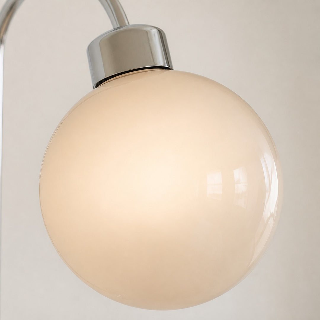 Pair of globe wall lamps installed beside a bathroom mirror