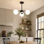 Load image into Gallery viewer, Black milk glass chandelier in a bright kitchen
