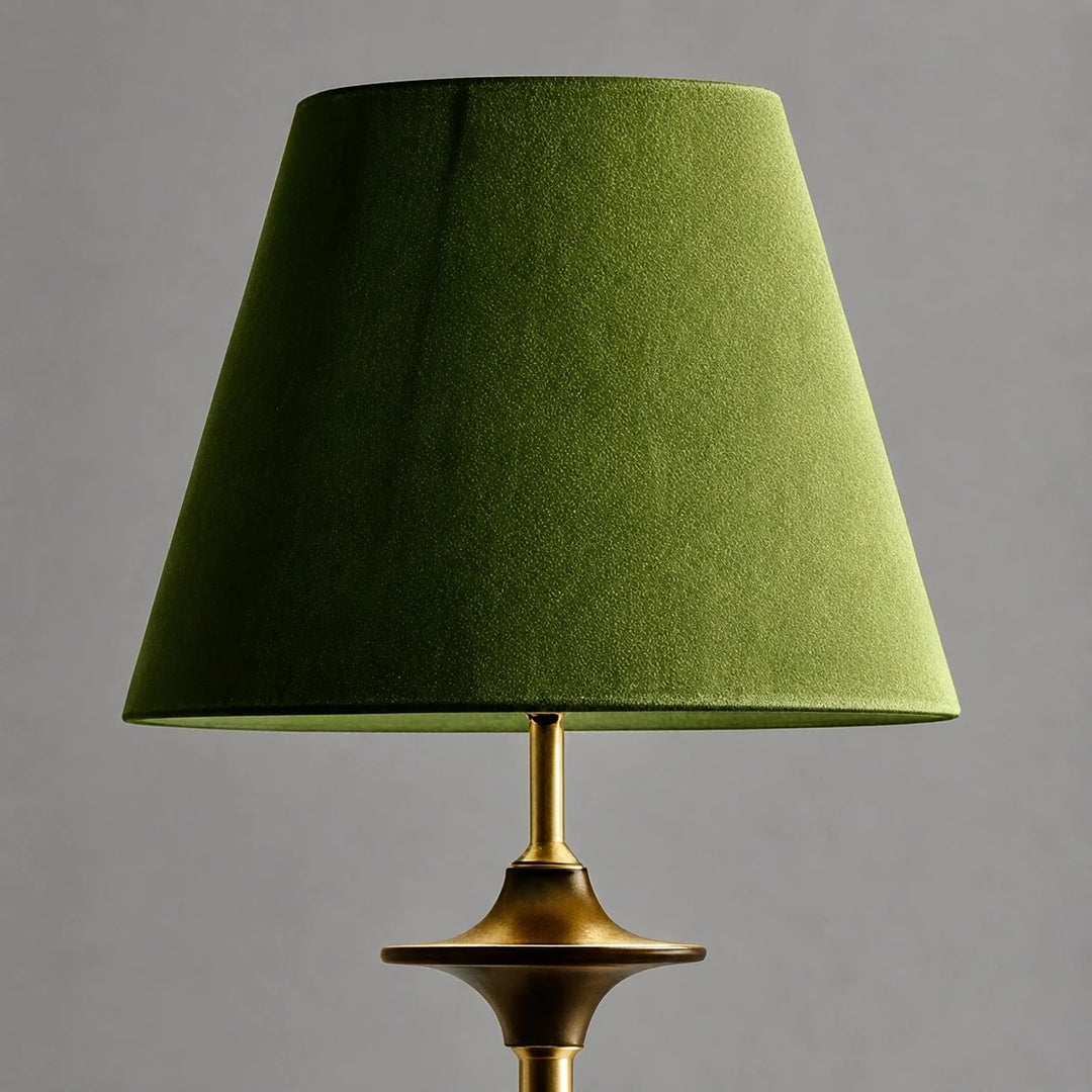 Close view of green fabric shade and brass tone stem