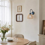 Bild in Gallery-Viewer laden, Woven rattan wall sconce in a dining space