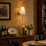 Bild in Gallery-Viewer laden, Vintage-inspired brass fabric wall sconce in a dining room