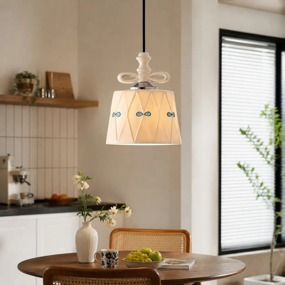 Ceramic bow pendant light above a bright dining table