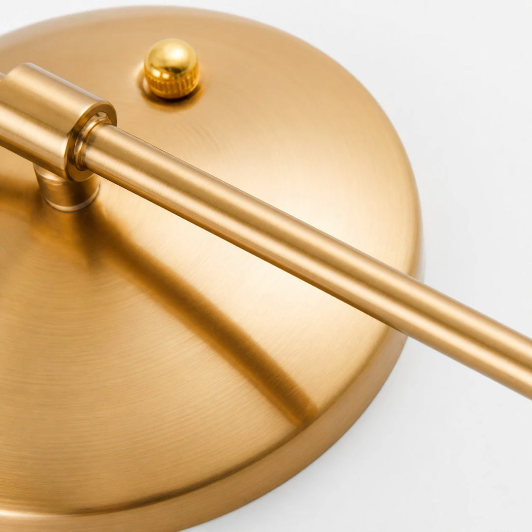Brushed gold wall plate and curved arm detail