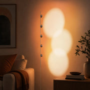 Sunset projection floor lamp glowing beside a lounge chair