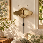 Charger l'image dans la visionneuse de galerie, Gold moth wall sconce beside a sofa and floral artwork