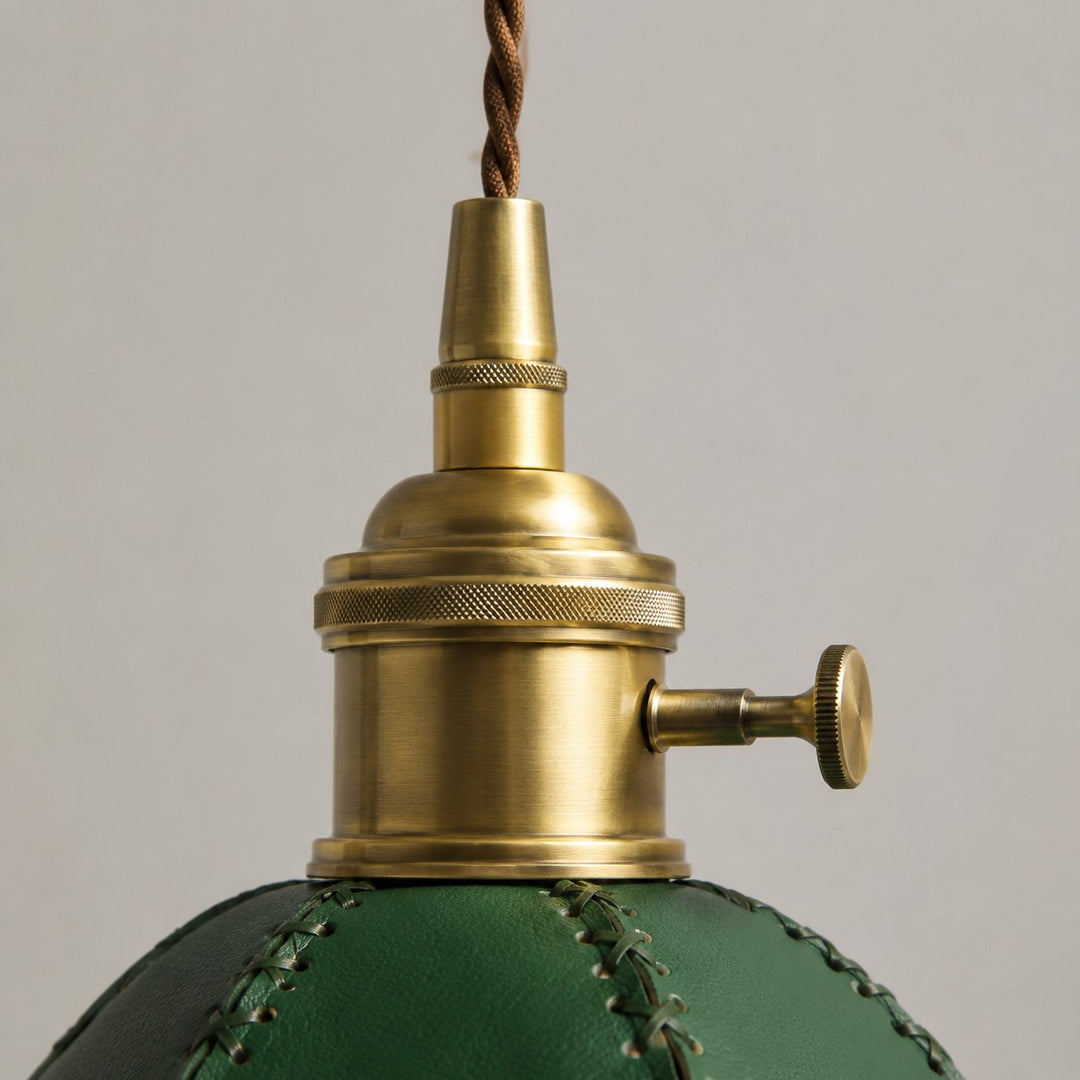 Close view of antique brass hardware on the leather pendant light