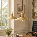 Bild in Gallery-Viewer laden, Pair of polished brass pendant lights above a dining table