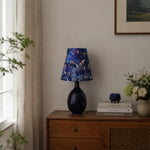 Load image into Gallery viewer, Blue floral fabric ceramic table lamp on a wooden cabinet