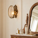 Load image into Gallery viewer, Antique brass textured glass wall sconce installed beside a vanity mirror