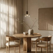 Clear brass glass pendant light installed above a round dining table