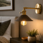 Load image into Gallery viewer, Hand-carved wall sconce beside a bed in a warm interior