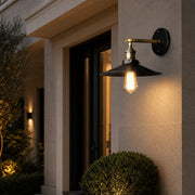 Outdoor wall lamp installed beside an entry door at night