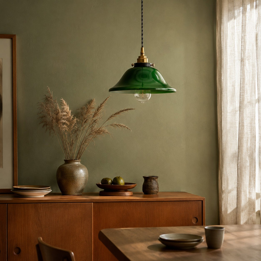 Green glass pendant light in a warm dining sideboard corner