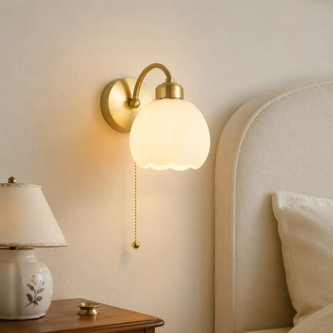 Milk glass flower wall lamp in a calm bedside setting