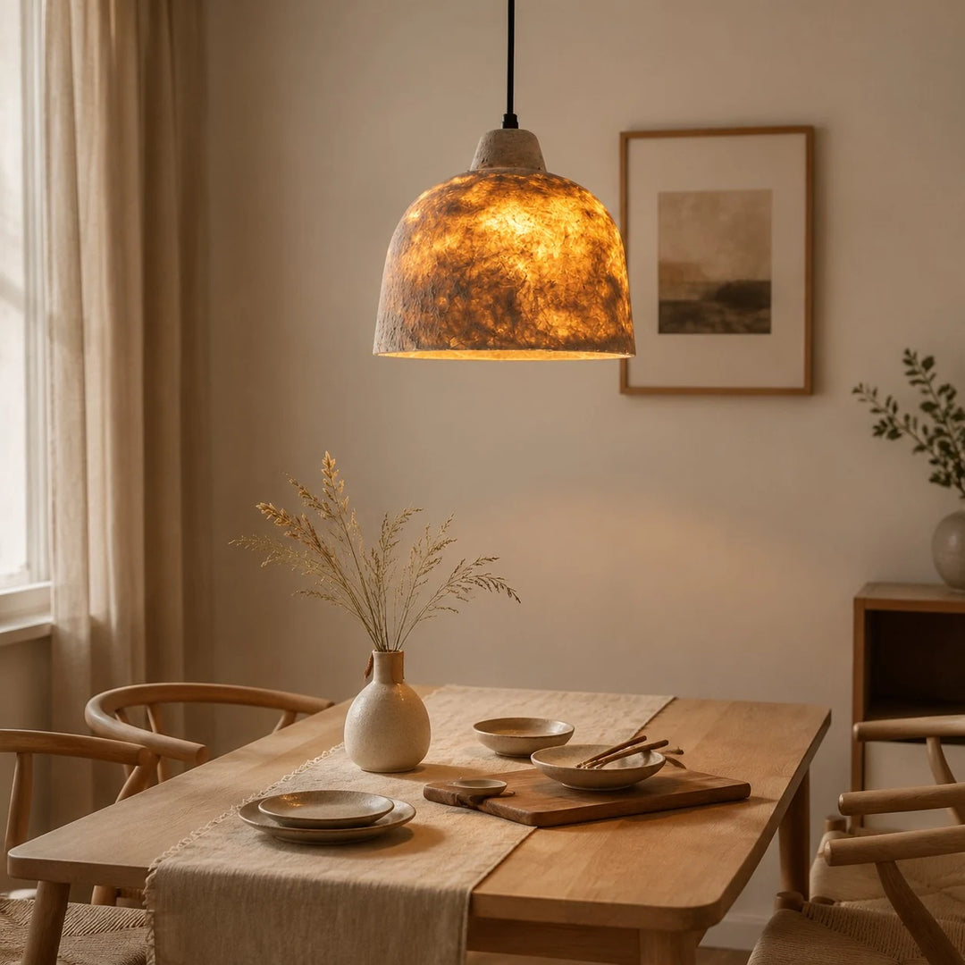Natural paper pendant light installed over a bright dining table