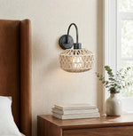 Bild in Gallery-Viewer laden, Woven rattan wall sconce beside a warm bedroom setting