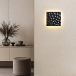 Load image into Gallery viewer, Ivory carved travertine wall sconce installed on a neutral wall