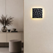 Ivory carved travertine wall sconce installed on a neutral wall