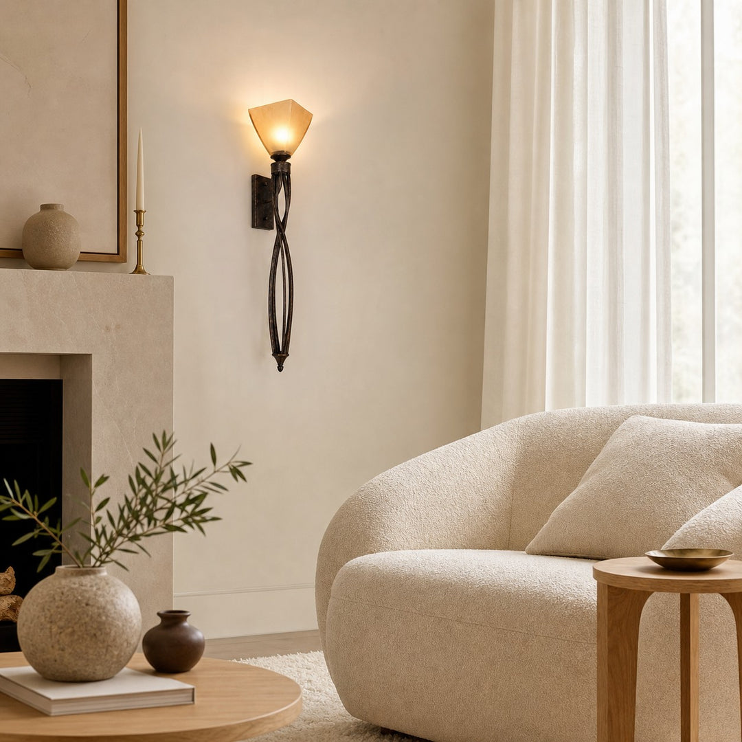 Tall amber glass wall sconce beside a fireplace