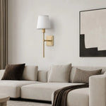 Load image into Gallery viewer, Single Head brass wall sconce above a light sofa in a warm living room