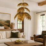 Cargar imagen en el visor de la Galería, Gold palm leaf chandelier in a warm living room