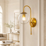 Bild in Gallery-Viewer laden, Gold clear-glass wall sconce in a bright living room