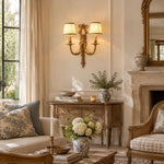 Bild in Gallery-Viewer laden, Two-head brass wall sconce with white shades in a refined living room