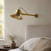 Matte brass wall light in a bedroom