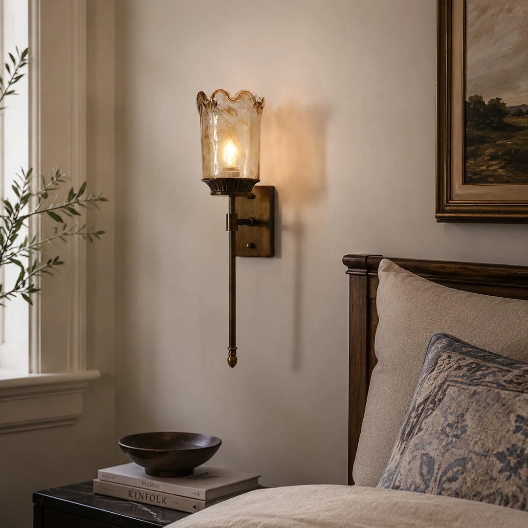 Vintage brass wall sconce installed beside a bedroom wall