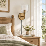 Bild in Gallery-Viewer laden, Tumbled-brass ribbed-glass sconce beside a bed in daylight