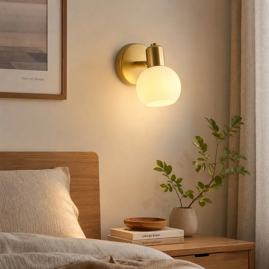 Single-light wall sconce beside a bed