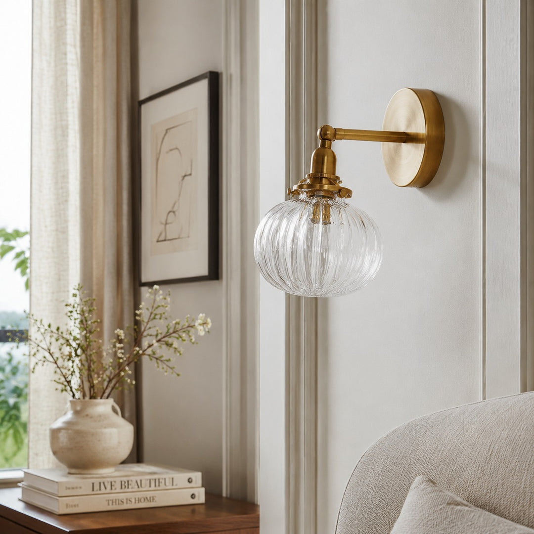 Brass ribbed glass wall light in a calm bedroom corner