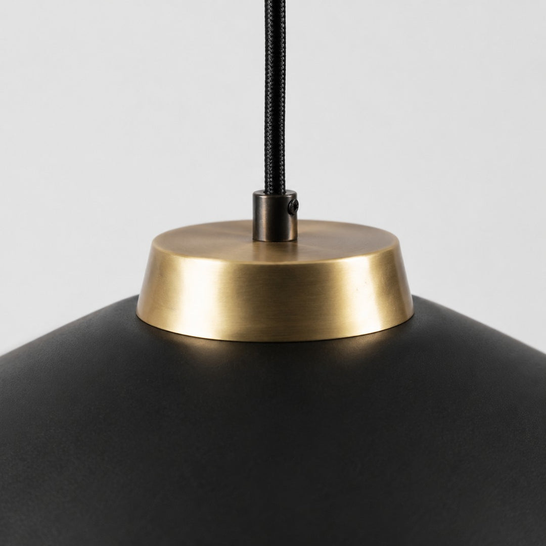 Close view of the black braided cord and brushed brass shade connector