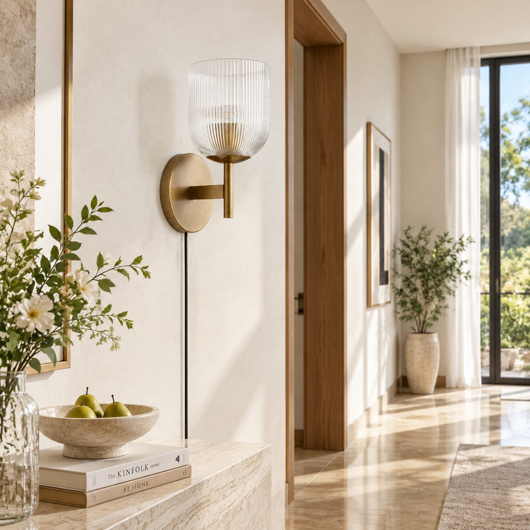 Tumbled-brass ribbed-glass sconce in a plaster hallway