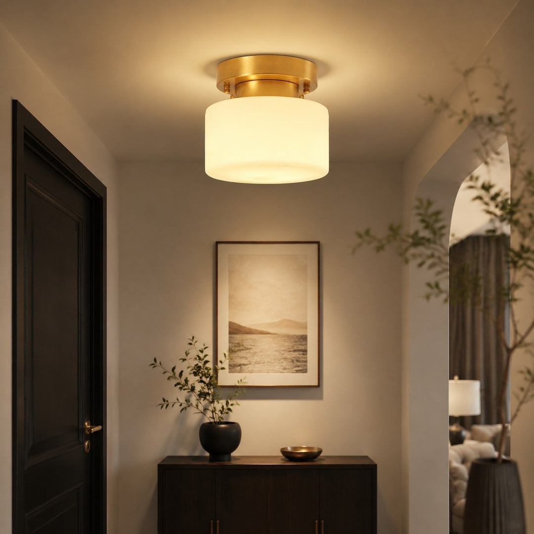 Brass flush mount ceiling light installed in a modern entryway